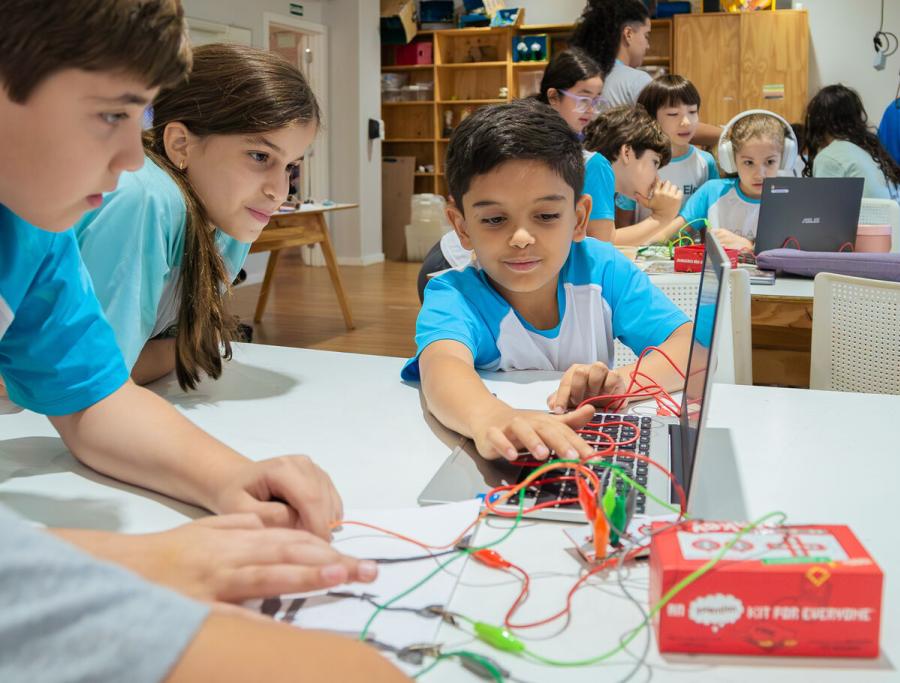 Students building a circuit with a robotics kit during a technology lesson at Escola Eleva Brasília