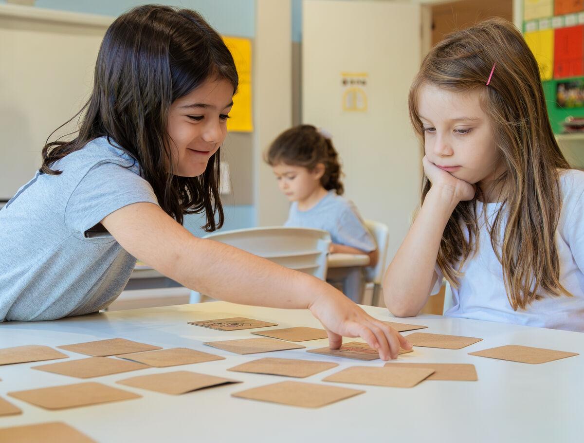 Elementary School students playing a card game at Escola Eleva Brasília in Asa Sul